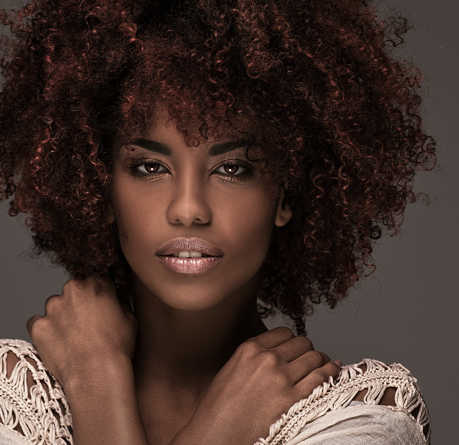 Woman with curly brown hair posing